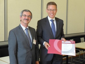 Dr. Ümit Ertürk (Mitglied des DGQ-Vorstands, links) gratuliert Dr. Michael Garmer zur 20-jährigen DGQ-Mitgliedschaft.